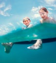 Sister and brother sitting on inflatable mattress and enjoying the sea water, cheerfully laughing when swim in the sea. Careless Royalty Free Stock Photo