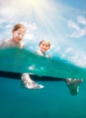 Sister and brother sitting on inflatable mattress and enjoying the sea water, cheerfully laughing when swim in the sea. Careless Royalty Free Stock Photo