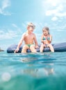 Sister and brother sitting on inflatable mattress and enjoying the sea water, cheerfully laughing when swim in the sea. Careless Royalty Free Stock Photo