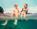 Sister and brother sitting on inflatable mattress and enjoying the sea water, cheerfully laughing when swim in the sea. Careless Royalty Free Stock Photo