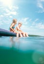 Sister and brother sitting on inflatable mattress and enjoying the sea water, cheerfully laughing when swim in the sea. Careless Royalty Free Stock Photo