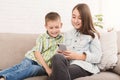 Sister and brother watching cartoons on smartphone together