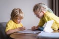 Sister helps little brother do school homework at home, Distance learning online education, boy and girl studying at