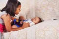 Sister playing with baby brother sleeping on sofa, Pune, Maharashtra Royalty Free Stock Photo