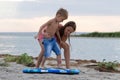 Sister teaching her brother how to surf