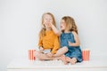 Sister trying to force-feed her brother with popcorn, he laughs