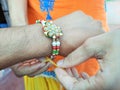 Sister tying up rakhee or holy thread on brother& x27;s hand on Raksha Bandhan