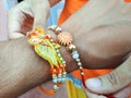 Sister tying up rakhee or holy thread on brother& x27;s hand on Raksha Bandhan