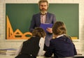 sisterhood. children girls and teacher man. Elementary School Teacher Giving Support In Classroom. Pupil Wearing Uniform