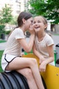 sisterhood, friendship. two charming teen girls having fun on a modern playground. sister, bffs communication