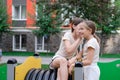 sisterhood, friendship. two charming teen girls having fun on a modern playground. sister, bffs communication