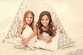 Sisters or best friends spend time together lay in tipi house. Girls having fun tipi house. Girlish leisure. Sisters Royalty Free Stock Photo