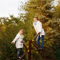 Sisters climbs the ladder on the playground. Royalty Free Stock Photo