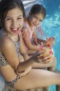 Sisters Drinking Juice By Poolside