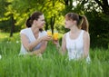 Sisters drinking orange juice in a park