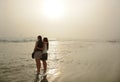 Sisters enjoying time together on beautiful foggy beach. Royalty Free Stock Photo