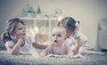 Sisters have play with baby brother. Royalty Free Stock Photo