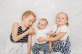 Sisters holding kissing little baby Royalty Free Stock Photo