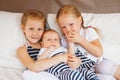 Sisters holding kissing little baby