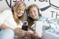 Sisters listening music through headphones at home Royalty Free Stock Photo