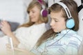 Sisters listening music through headphones at home Royalty Free Stock Photo