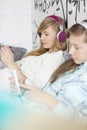 Sisters listening music through headphones at home Royalty Free Stock Photo