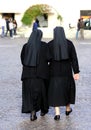 Sisters with long blacks clothes they walk through the streets o Royalty Free Stock Photo