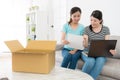 Sisters looking at online shopping parcel list Royalty Free Stock Photo