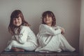 Sisters in nightgowns play on old trunk