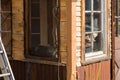 A cat rests in the corner of a window of a wooden house in Sisters, Oregon, USA.