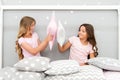 Sisters play pillows bedroom party. Pillow fight pajama party. Evening time for fun. Sleepover party ideas. Girls happy Royalty Free Stock Photo