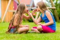 Sisters playing in garden eating strawberries