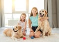 Sisters playing with golden retrievers