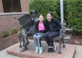 Sisters posing with bronze of Will Rogers on a bench, Claremore, Oklahoma