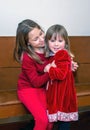 Sisters in red hugging each other Royalty Free Stock Photo