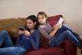 Sisters relaxing together at home on sofa Royalty Free Stock Photo
