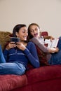 Sisters relaxing together at home on sofa Royalty Free Stock Photo