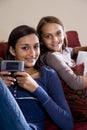 Sisters relaxing together at home on sofa Royalty Free Stock Photo