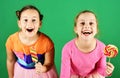 Sisters with round and long shaped lollipops. Royalty Free Stock Photo