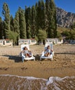 Sisters on sand beach lying on deck chairs Royalty Free Stock Photo