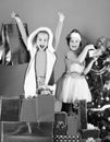 Sisters in Santa Claus hats with gift boxes receive presents. Royalty Free Stock Photo