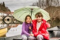 Sisters sitting in the boat on the river and holding the umbrella Royalty Free Stock Photo