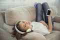 Sisters teenage girls with smart phone and headphones listening music and ommunicate in social networks