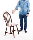 Sit down please. A man in casual style wear shows wooden rustic chair. Man and chair isolated on white background.