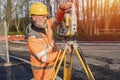Site engineer setting his instrument during roadworks. Builder installing total positioning station tachymeter on construction Royalty Free Stock Photo