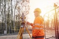 Site engineer setting his instrument during roadworks. Builder installing total positioning station tachymeter on construction Royalty Free Stock Photo