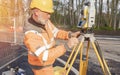 Site engineer setting his instrument during roadworks. Builder installing total positioning station tachymeter on construction Royalty Free Stock Photo