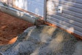 On the site of a new home in the process of construction, a worker pours wet concrete as he paves a driveway. Royalty Free Stock Photo
