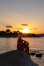 Sithonia - Silhouette of sitting tourist woman relaxing with scenic view of sunset over Aegean Mediterranean Sea on Karydi beach Royalty Free Stock Photo