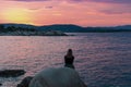 Sithonia - Silhouette of sitting tourist woman relaxing with scenic view of sunset over Aegean Mediterranean Sea on Karydi beach Royalty Free Stock Photo